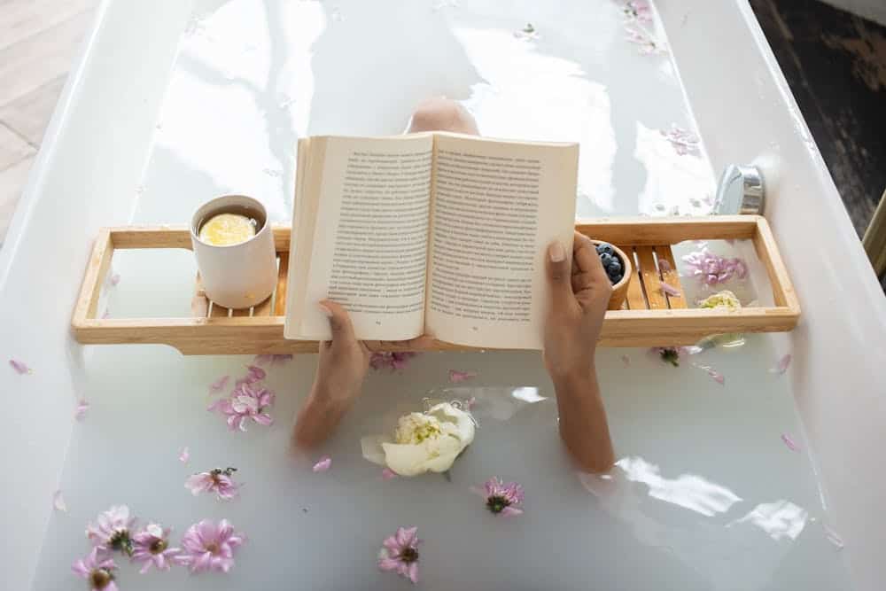 Woman enjoying DIY milk bath with freeze dried milk while reading and relaxing