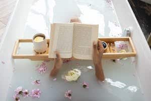 Woman enjoying DIY milk bath with freeze dried milk while reading and relaxing
